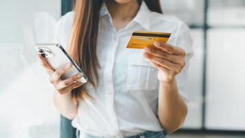 Business technology concept, Close-up of a woman's hands holding a smartphone and credit card, ready to make an online transaction. photo