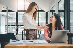 Business team concept, Two colleagues sharing a light-hearted moment during a productive workday in a sunny, contemporary office setting. photo