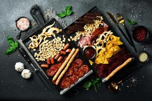 Antipasto, Appetizers for beer salami, cheese, nuts and sausages. On a dark background, close-up. photo