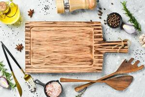 Cooking banner. Kitchen wooden board and spices on concrete table. Free space for text. Rustic style. photo