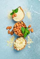 Almonds and almond flour in bowls. On a concrete background. Top view. Copy space. photo