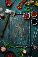 Kitchen board with vegetables, spices and utensils. On a dark background. Top view. Free space for text. photo