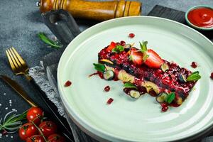 Goose pate with berry jam. Restaurant serving of food on a plate. On a black stone background. Free space for text. photo