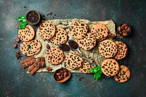 Cookies with chocolate chips and cocoa. Traditional American cookies. On a dark stone background. Space for text. photo