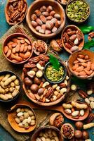 peeled and shelled nuts in wooden bowls. Top view. On a dark background. photo