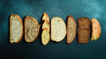 Slices of different types of bread. Assortment of rye, bran and sourdough bread. Top view. photo