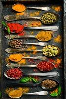 A set of colored spices in spoons. Cooking. Vertical photo. Top view. photo