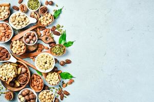 Assortment of nuts in bowls. Cashew, hazelnuts, walnuts, pistachio, pecans, pine nuts, peanut. Food mix background, top view, copy space. photo