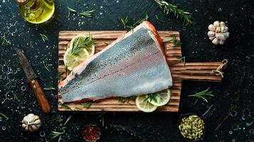 Raw salmon fillet on a wooden board. Recipe. Top view. Seafood. photo