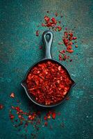 Dried red hot pepper in a bowl. Spices and condiments. Top view. On a textured background. photo