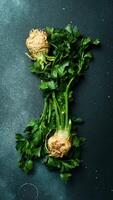 Celery. Fresh celery root and celery stalk. Vegetables for detox and diet. On a black stone background. Top view. photo