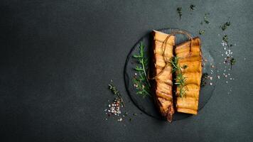 Smoked pork ribs with spices and herbs on a slate plate. Top view. Free space for text. photo