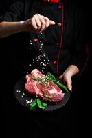 Beef steak and salt by chef on the background with free space for text design or logotype menu restaurant. Meat. On a black background. photo