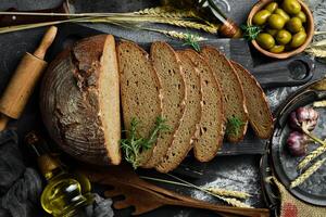 Fresh Sourdough Bread on black background. Fresh baked homemade sliced rye bread. Top view. photo