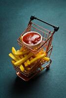 French fries and ketchup sauce. Advertising photo. Free space for text. On a dark background. photo