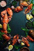 Lobster. Banner, free space for text. grilled lobster, crab and crayfish with lemon and basil on a black slate board. photo