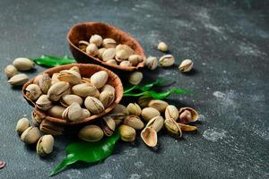 Roasted salted pistachios in a wooden bowl. Nuts Healthy snacks. photo