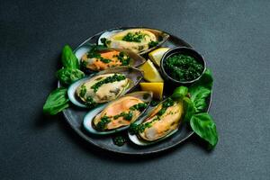 Close up of delicious steamed mussels. On a black stone plate. Seafood. photo