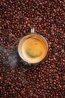 A cup of freshly brewed hot espresso coffee. roasted coffee bean background, top view. Free space for text. photo