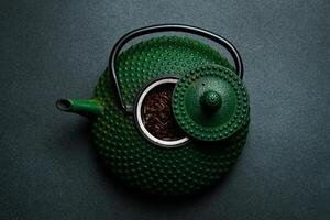 Traditional Japanese teapot for brewing tea. On a black stone background. Top view. Free space for text. photo