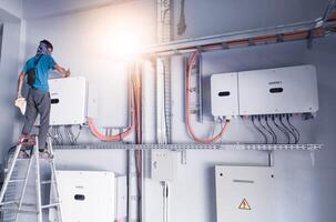 technician is carrying out maintenance on a solar power inverter panel, the concept of regular maintenance on an inverter. photo