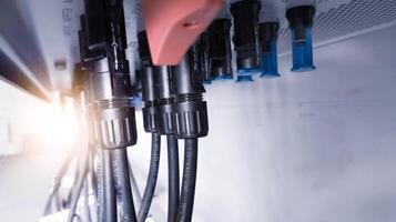 Cable connecting the power from the solar panel to the inverter with shiny light. Cable string connection on inverter control solar panel. Socket input supply voltage and Technology of solar energy. photo