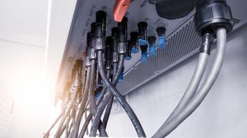 Cable connecting the power from the solar panel to the inverter with shiny light. Cable string connection on inverter control solar panel. Socket input supply voltage and Technology of solar energy. photo