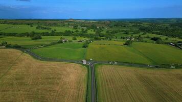 aereo Visualizza di un' rurale paesaggio con verde campi, strade, e alberi sotto un' blu cielo. video