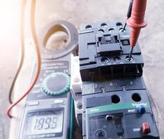 the process of repairing electrical components on the machine control panel, an electrician uses a screwdriver to repair the electical control circuit components.tightening  the terminals cable power. photo