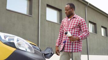 africano americano masculino desliga poder conector para dentro carga caminhão ev carro video