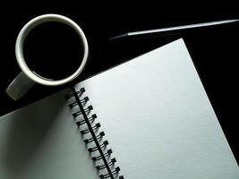 Close up blank page with coffee on black background. photo