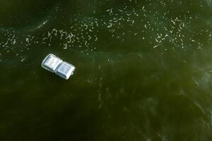 The foam box fragments in the dirty sea. photo