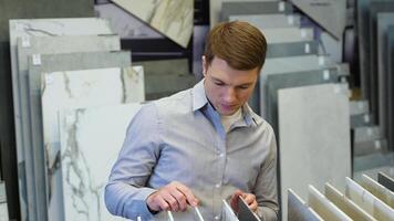 A man buyer browsing tile samples in home improvement store video