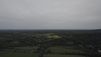 Overcast sky over a lush landscape with patches of yellow fields. video