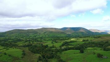 Panoramic view of lush green hills under a cloudy sky, showcasing the natural beauty of a rural landscape. video