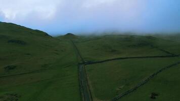 Misty landscape with green hills and a narrow road, evoking tranquility and isolation. video