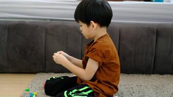 asiatisk pojke spelar med plastin i de rum video