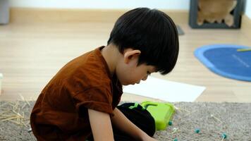 Asian boy playing with plasticine in the room video