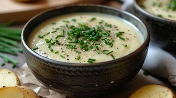 ai generado un cuenco de cremoso patata Puerro sopa, sedoso en textura y adornado con Fresco cebollín. foto