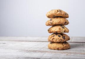 golden cookie tower with pieces of chocolate on wooden background photo