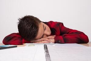 depressed child on the table in class, with school supplies on the table photo