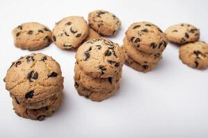 lots of cookies with chips and pieces of chocolate on white background photo