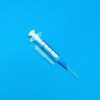 Insulin syringe closeup on blue background. The concept of fighting diabetes. photo