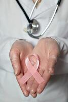 Pink cancer awareness ribbon on doctor's coat. World Cancer Day photo