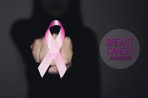 Pink ribbon with text Breast Cancer Awareness, symbolic bow color raising awareness on people living with women's breast tumor illness. photo