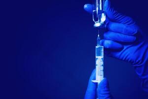 Syringe and hand closeup. The concept of vaccination, filling the drug into the syringe photo