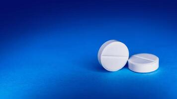 White tablet on a blue background. medicine preparations photo