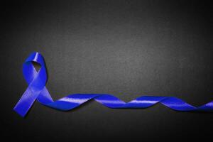 medicine, health care and symbolics concept - close up of blue prostate cancer awareness ribbon photo