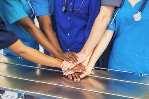 doctores y enfermeras coordinar manos. concepto trabajo en equipo en hospital para éxito trabajo y confiar en equipo foto