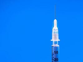 Insulin syringe closeup on blue background. diabetes photo
